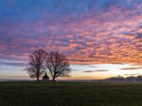Rötlich leuchtende Wolkenschicht am Morgen rechts der Kriegergedächtniskapelle Hittenkirchen
